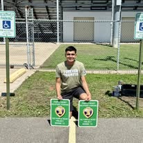 Volunteer with newly installed Purple Heart Recipient Parking signs