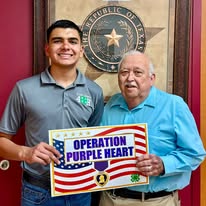 Purple Heart Project volunteers holding an Operation Purple Heart sign